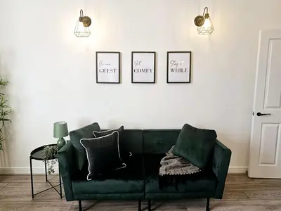 a green couch in a living room with three pictures on the wall at Falkner Square in Liverpool