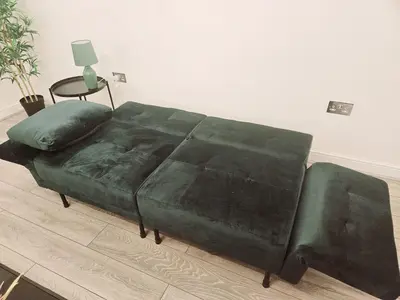 a green couch in a living room with a table at Falkner Square in Liverpool