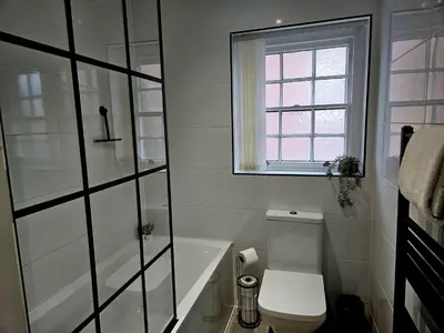 a bathroom with a toilet and a tub and a window at Falkner Square in Liverpool