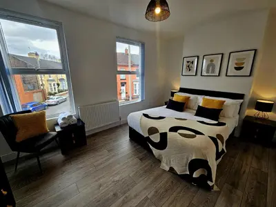 a bedroom with a bed and a large window at Anfield House in Liverpool