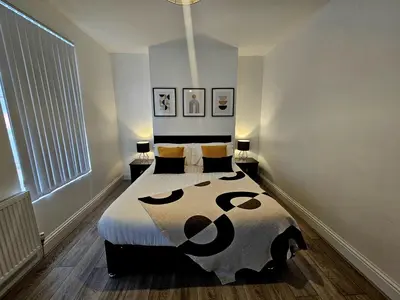 a bedroom with a bed with a black and white comforter at Anfield House in Liverpool