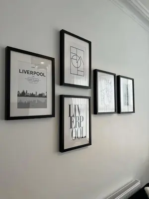 a group of four framed pictures on a wall at Anfield House in Liverpool