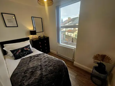 a bedroom with a bed and a large window at Anfield House in Liverpool