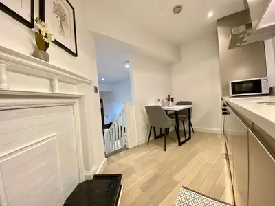 a kitchen and dining room with a table and a counter at Lennon Place in Liverpool