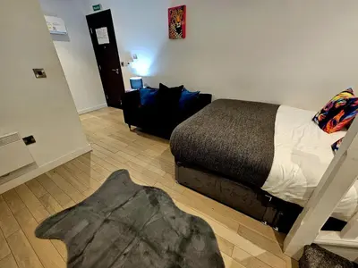 a bedroom with a bed and a chair in it at Lennon Place in Liverpool