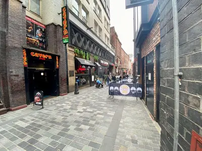 an empty street in a city with buildings at Lennon Place in Liverpool