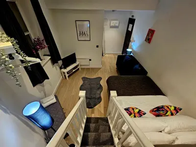 a small room with two beds and a staircase at Lennon Place in Liverpool