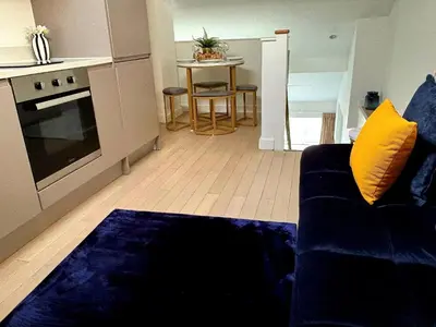 a living room with a blue couch and a kitchen at McCartney Place at the Cavern Quarter in Liverpool