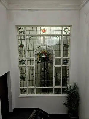 a stained glass window in a room with a plant at McCartney Place at the Cavern Quarter in Liverpool