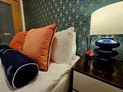 a bed with a pillow and a lamp on a table at McCartney Place at the Cavern Quarter in Liverpool