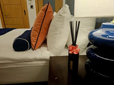 a bed with pillows and a vase on a table at McCartney Place at the Cavern Quarter in Liverpool