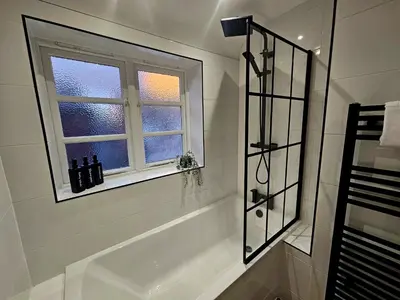 a bathroom with a bath tub and a window at Rodney Street in Liverpool