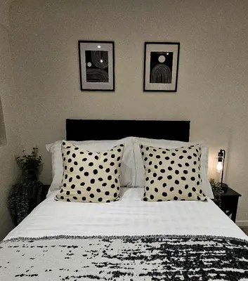a bedroom with a bed with black and white pillows at Rodney Street in Liverpool
