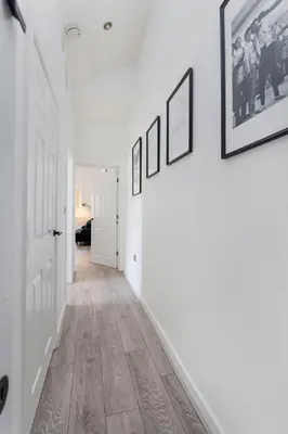 a hallway with paintings on the walls and a hallway with wooden floors at Rodney Street in Liverpool