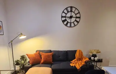 a living room with a couch and a clock on the wall at Rodney Street in Liverpool