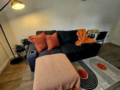 a living room with a black couch with pillows at Rodney Street in Liverpool