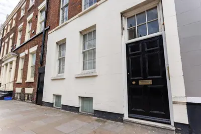 a black door on the side of a white building at Rodney Street in Liverpool