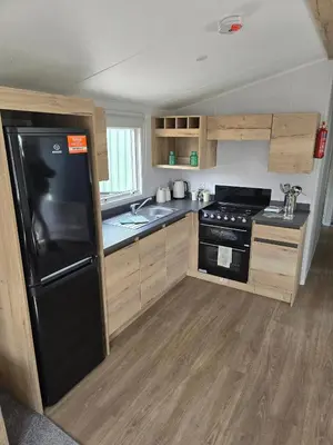 a kitchen with a black refrigerator and a sink at 8 berth Caravan in Morecambe