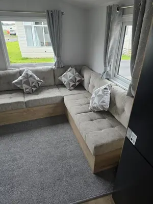 a couch in a living room with pillows on it at 8 berth Caravan in Morecambe