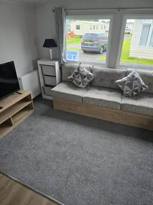 a living room with a couch and a window at 8 berth Caravan in Morecambe