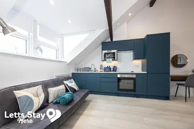 a living room with a couch and a kitchen at Eden Bay Serviced Apartments - Eden in Morecambe