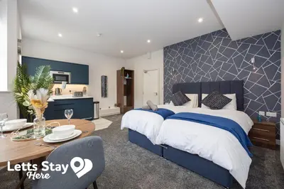 a bedroom with a large bed and a dining room at Eden Bay Serviced Apartments - Eden in Morecambe