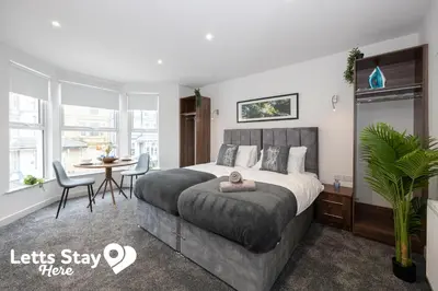 a bedroom with a bed and a table and chairs at Eden Bay Serviced Apartments - Eden in Morecambe
