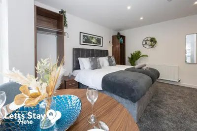 a bedroom with a bed and a table with a table sidx sidx sidx at Eden Bay Serviced Apartments - Eden in Morecambe