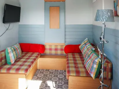 a room with two couches and a tv at Sunset Cabin in Ormskirk