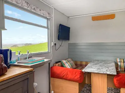 a room with a kitchen with a sink and a window at Sunset Cabin in Ormskirk