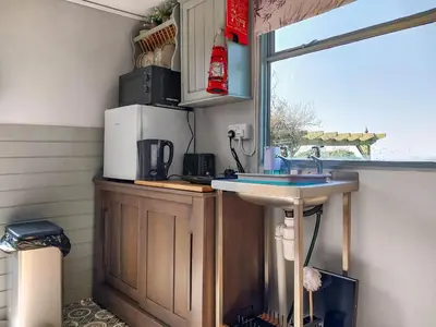 a kitchen with a sink and a window at Sunset Cabin in Ormskirk