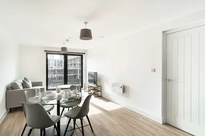a white living room with a glass table and chairs at Spacious & Bright 1 Bed Apartment in Liverpool in Liverpool