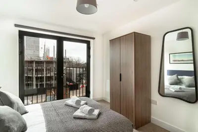 a bedroom with a mirror and a bed with towels at Spacious & Bright 2 Bed Apartment in Liverpool in Liverpool