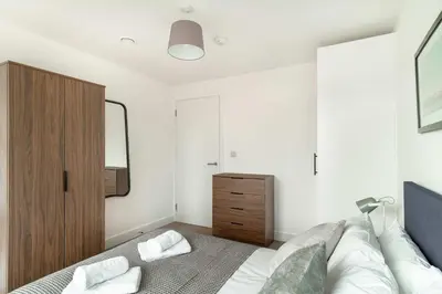 a bedroom with a bed and a wooden cabinet at Spacious & Bright 2 Bed Apartment in Liverpool in Liverpool