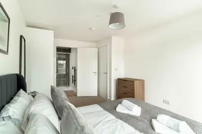 a bedroom with a bed with white sheets and pillows at Spacious & Bright 2 Bed Apartment in Liverpool in Liverpool