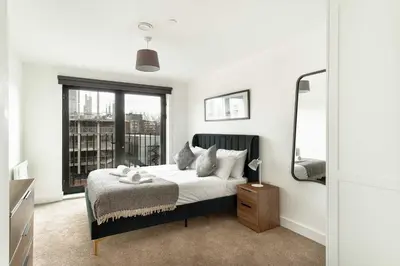 a bedroom with a bed and a large window at Spacious & Bright 2 Bed Apartment in Liverpool in Liverpool