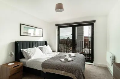 a bedroom with a bed and a large window at Stunning 2 Bedroom Apartment in Liverpool w Views in Liverpool