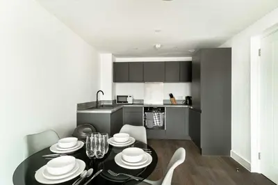 a kitchen with a black table with white dishes on it at Stunning 2 Bedroom Apartment in Liverpool w Views in Liverpool