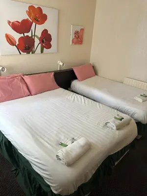 two beds in a hotel room with towels on them at Balin Helmshore in Blackpool