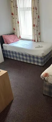 a small bed in a room with a window at Balin Helmshore in Blackpool