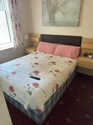 a bedroom with a bed with a floral blanket at Balin Helmshore in Blackpool