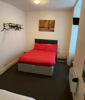 a bedroom with a bed with red pillows at Balin Helmshore in Blackpool