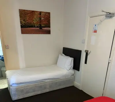 a small bed in a room with a painting on the wall at Balin Helmshore in Blackpool