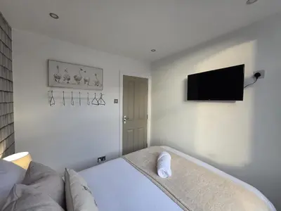 a bedroom with a bed and a flat screen tv at #18 Anfield 5 min walk Sleeps 7 4BR 5Bed 3Bathrms in Liverpool