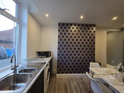 a kitchen with a sink and a wall with a window at #18 Anfield 5 min walk Sleeps 7 4BR 5Bed 3Bathrms in Liverpool
