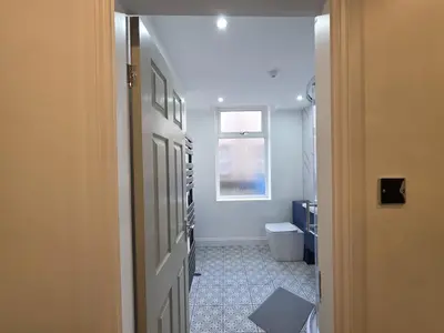 a hallway with a bathroom with a toilet and a window at #18 Anfield 5 min walk Sleeps 7 4BR 5Bed 3Bathrms in Liverpool