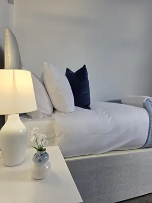 a couch with pillows and a table with a lamp at #18 Anfield 5 min walk Sleeps 7 4BR 5Bed 3Bathrms in Liverpool