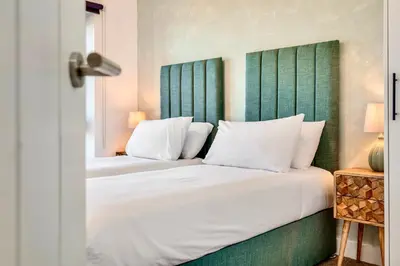 a bedroom with a bed with a green headboard at Luxury City Escape - Brand New Stylish 2 Bedroom Apartment with Parking in Liverpool
