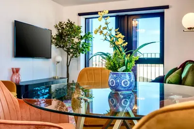 a vase with flowers on a glass table in a living room at Luxury City Escape - Brand New Stylish 2 Bedroom Apartment with Parking in Liverpool