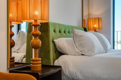 a bedroom with a bed with two lamps and a mirror at Luxury City Escape - Brand New Stylish 2 Bedroom Apartment with Parking in Liverpool